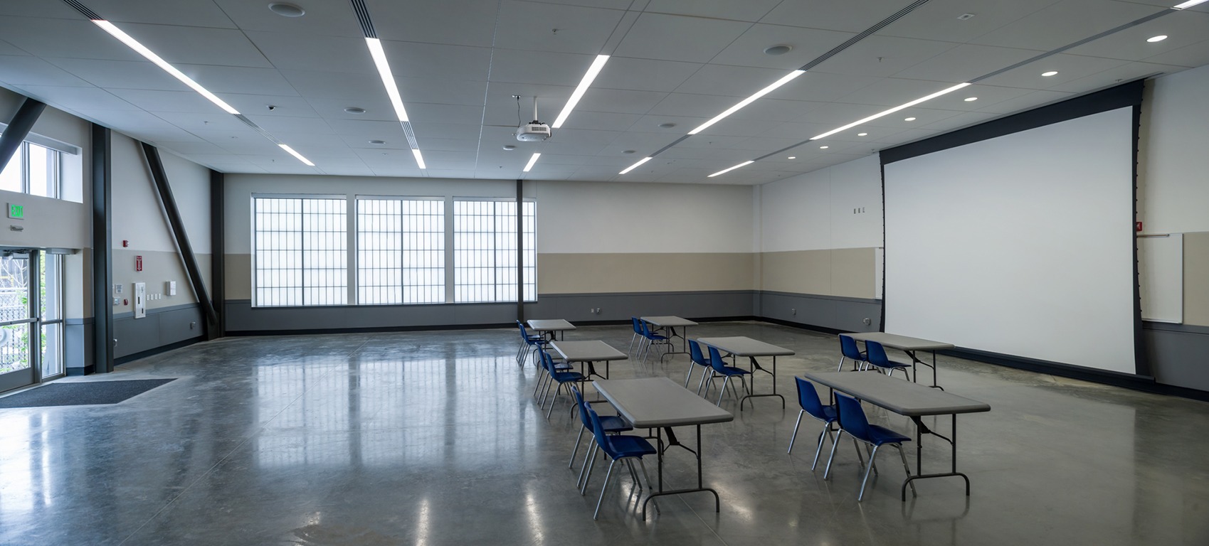 Large training room with concrete floors and oversized windows.